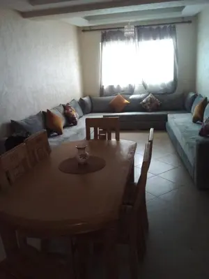 a living room with a table and a couch at BOUZNIKA Appartement in Bouznika