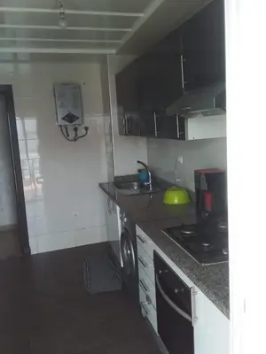 a kitchen with a stove and a counter top at BOUZNIKA Appartement in Bouznika