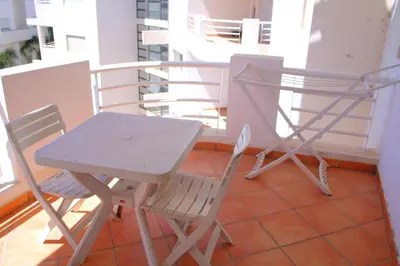 a table and two chairs sitting on a balcony at BOUZNIKA Piscine et plage in Bouznika
