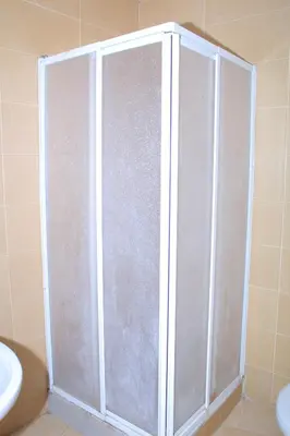 a shower stall in a bathroom next to a toilet at BOUZNIKA Piscine et plage in Bouznika