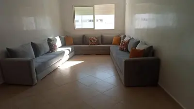 a living room with two couches and a window at BOUZNIKA Piscine et plage in Bouznika