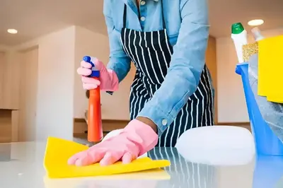 a woman in pink gloves cleaning a table with a sponge at STUDIO HAUT STANDING A RACINE near twin center in Casablanca