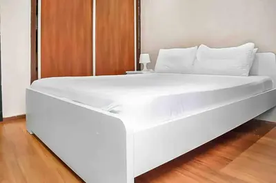 a large white bed in a room with a wooden floor at Gauthier studio in Casablanca