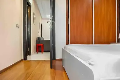 a bedroom with a white bed and a red chair at Gauthier studio in Casablanca