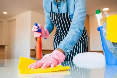 a woman in pink gloves cleaning a table with a sponge at Gauthier studio in Casablanca