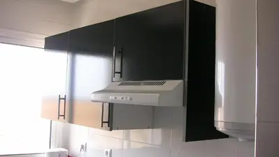 a kitchen with black cabinets and a white stove top oven at La Belle Echappée in Bouznika