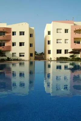 a swimming pool in front of two buildings at Les jardins du soleil in Mohammedia