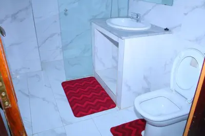 a white bathroom with a sink and a toilet at Les jardins du soleil in Mohammedia