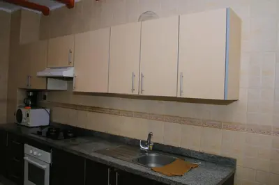 a kitchen with a sink and white cabinets at Les jardins du soleil in Mohammedia