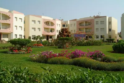 a park with flowers in front of some buildings at La Perle de la Côte Atlantique in Mohammedia