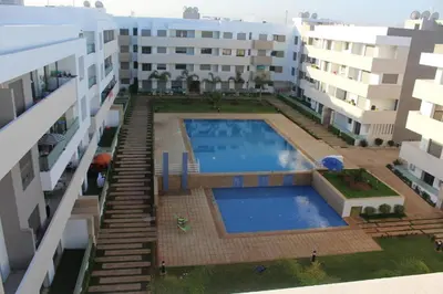 an overhead view of a swimming pool between two buildings at Apparentement des jardins paisibles in Mohammedia