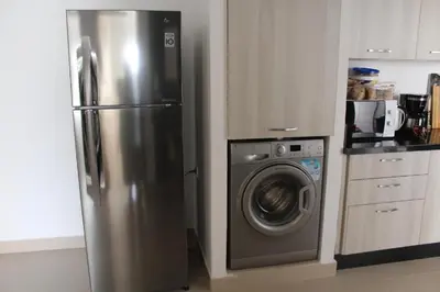 a stainless steel refrigerator and a washing machine in a kitchen at Appartement du bonheur Paradise in Mohammedia