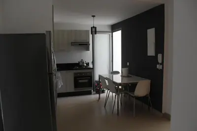 a kitchen with a table and chairs in a room at Appartement du bonheur Paradise in Mohammedia