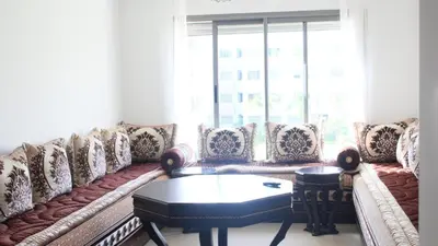 a living room with a couch and a table at Appartement du bonheur Paradise in Mohammedia