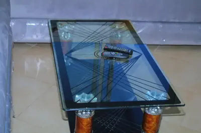 a glass table with a remote control on top of it at BOUZNIKA T2 in Bouznika