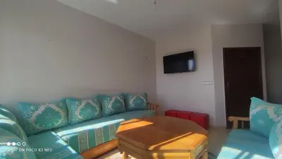 a living room with a blue couch and a table at Appartement près de casanearshore et l'OFPPT in Casablanca