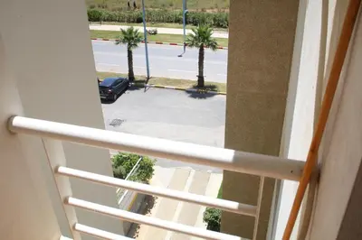 a view from a window of a parking lot with palm trees at Le paradis du pêcheur BOUZNIKA in Bouznika