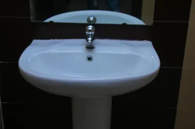 a white sink in a bathroom with a mirror at Le paradis du pêcheur BOUZNIKA in Bouznika