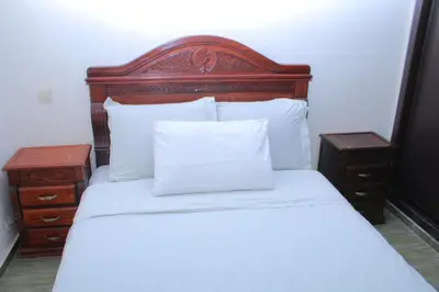a bed with a wooden headboard and two night stands at Le paradis du pêcheur BOUZNIKA in Bouznika