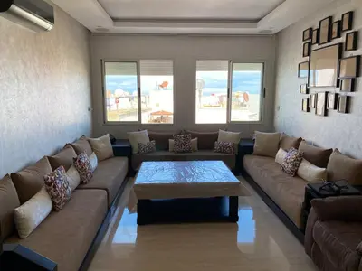 a living room with a couch and a coffee table at Magnifique F3 rénové Fibre, Parking & excellente desserte in Casablanca