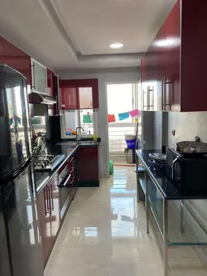 a kitchen with stainless steel appliances and red cabinets at Magnifique F3 rénové Fibre, Parking & excellente desserte in Casablanca