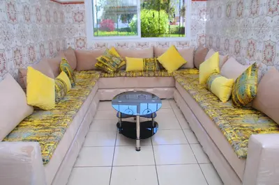 a couch with pillows and a table on it at Les temps heureux MOHAMMEDIA in Mohammedia