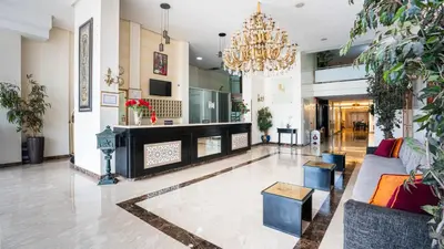 a living room with a fireplace and a chandelier at Hotel Al Walid in Casablanca