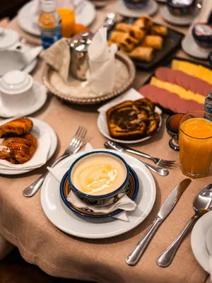 a table with plates of food and a cup of coffee at Hotel Al Walid in Casablanca