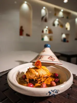 a plate of food with a chicken and fruit on a counter at Hotel Al Walid in Casablanca