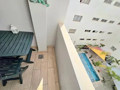 a view of a balcony with a table and an umbrella at Joli appartement Mohammédia in Mohammedia