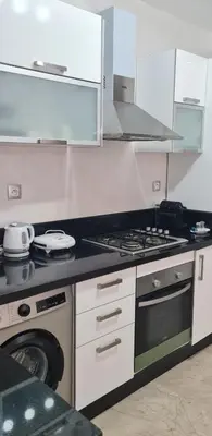 a kitchen with a stove and a washing machine at Joli appartement Mohammédia in Mohammedia