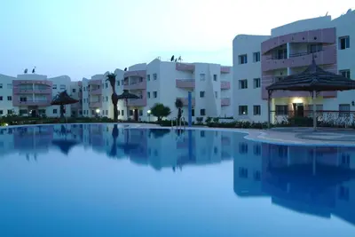 a swimming pool in front of some apartment buildings at Appartement Mimousa in Mohammedia