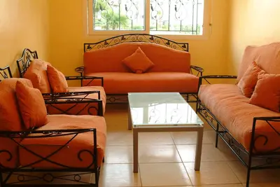 a living room with two couches and a glass table at Appartement Mimousa in Mohammedia