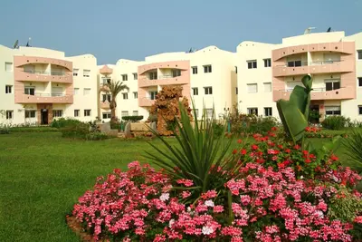 a view of a building with flowers in a yard at Appartement Mimousa in Mohammedia