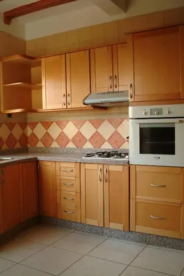 a kitchen with wooden cabinets and a stove top oven at Appartement Mimousa in Mohammedia