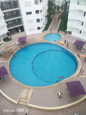 an overhead view of a large swimming pool with umbrellas at BOUZNIKA 78 in Bouznika