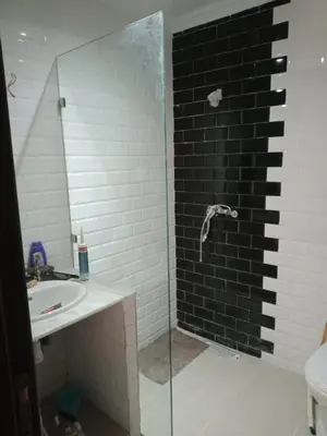 a bathroom with a glass shower and a sink at BOUZNIKA 78 in Bouznika