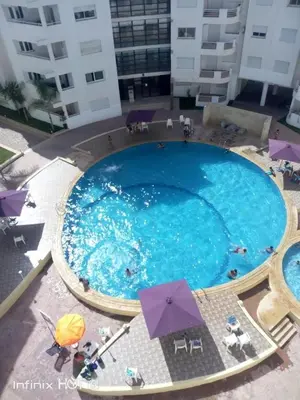 an overhead view of a large swimming pool with umbrellas at Séjour à Bouznika in Bouznika