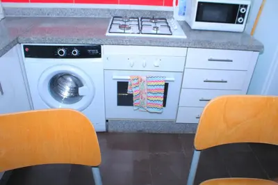 a kitchen with a stove and a washing machine at BOUZNIKA CH1 98 in Bouznika