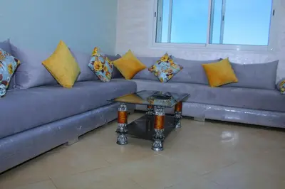 a couch with pillows and a table in a living room at BOUZNIKA CH1 98 in Bouznika