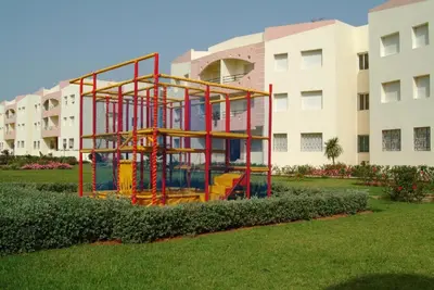 a play structure in front of a building at MOHAMMEDIA Appartement avec 3 piscines et prés de plage in Mohammedia