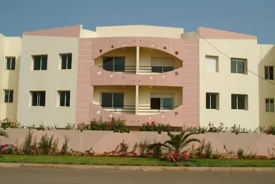 a pink building with flowers in front of it at MOHAMMEDIA Résidence avec piscines in Mohammedia