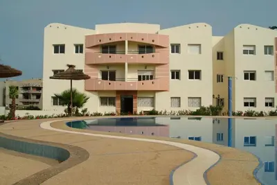 a building with a swimming pool in front of a building at Elégant appartement in MOHAMMEDIA in Mohammedia