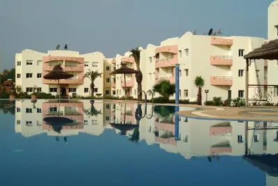 a reflection of buildings in a pool of water at Super Appartement MOHAMMEDIA in Mohammedia