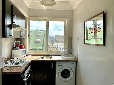 a kitchen with a washing machine and a window at Sab 8 - Amazing view. 2 bedrooms in front of the mosque Hassan. Perfect location in Casablanca