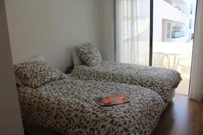 a bedroom with a bed and a chair and a window at MOHAMMEDIA piscine et plage in Mohammedia