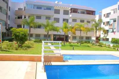 a swimming pool in front of a building at MOHAMMEDIA L Oasis maritime in Mohammedia