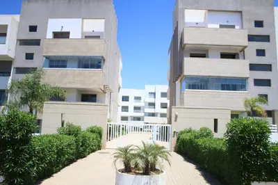 a building with a walkway in front of a building at MOHAMMEDIA L Oasis maritime in Mohammedia
