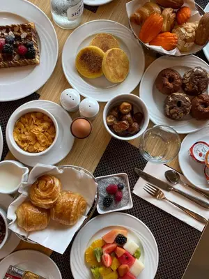 a wooden table with plates of food on it at Hilton Garden Inn Casablanca Sud in Casablanca