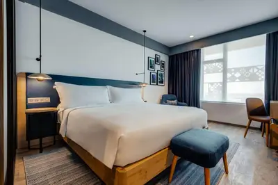 a hotel room with a large bed and a chair at Hilton Garden Inn Casablanca Sud in Casablanca